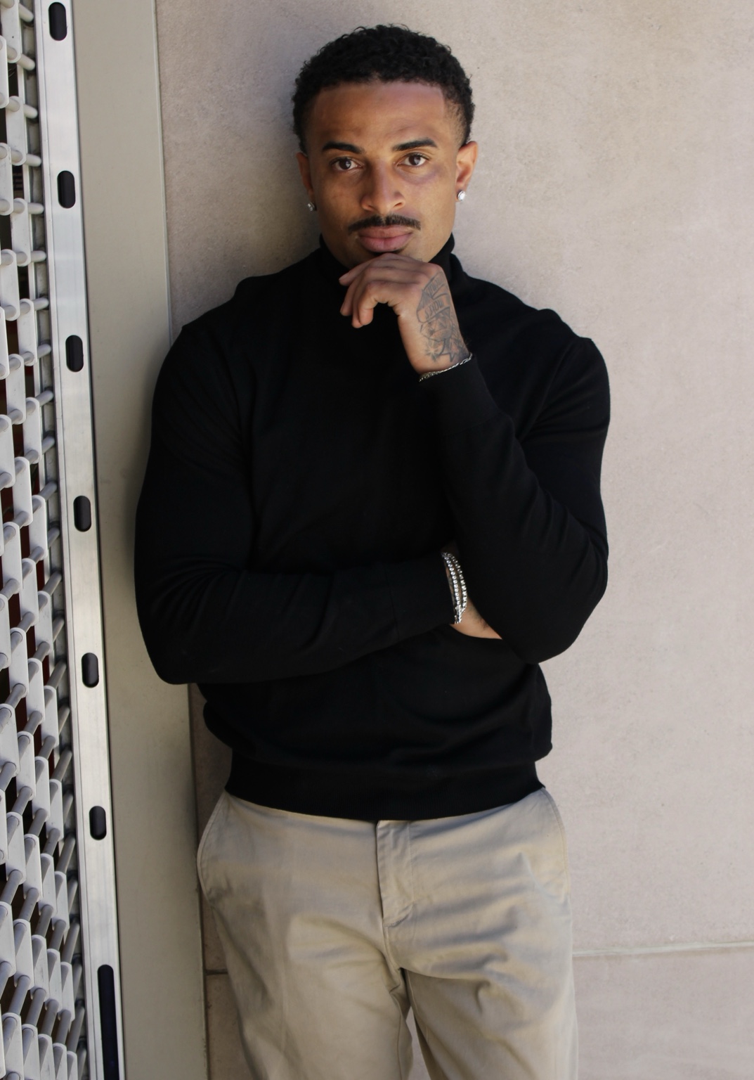 James Muhammad Denver actor and commercial model in a black turtleneck with hand posed at chin
