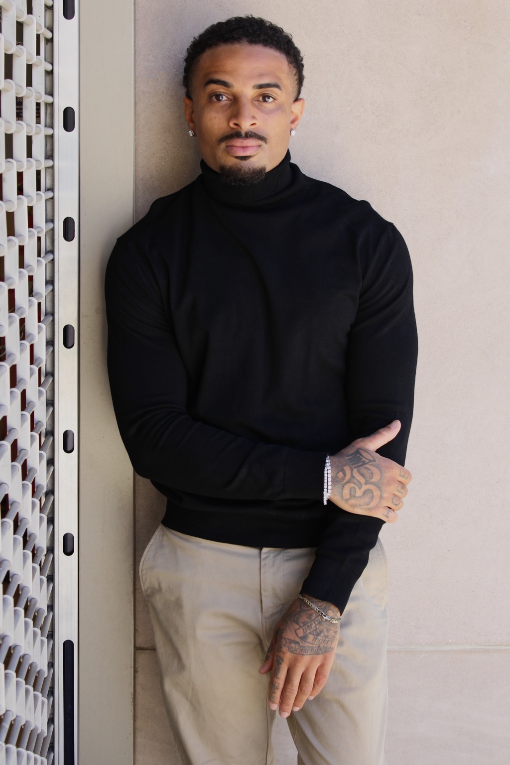 James Muhammad Denver actor and commercial model in a black turtleneck and khaki trousers