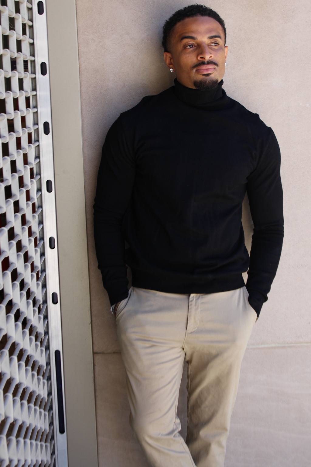James Muhammad Denver actor and commercial model in a black turtleneck leaning against a neutral wall