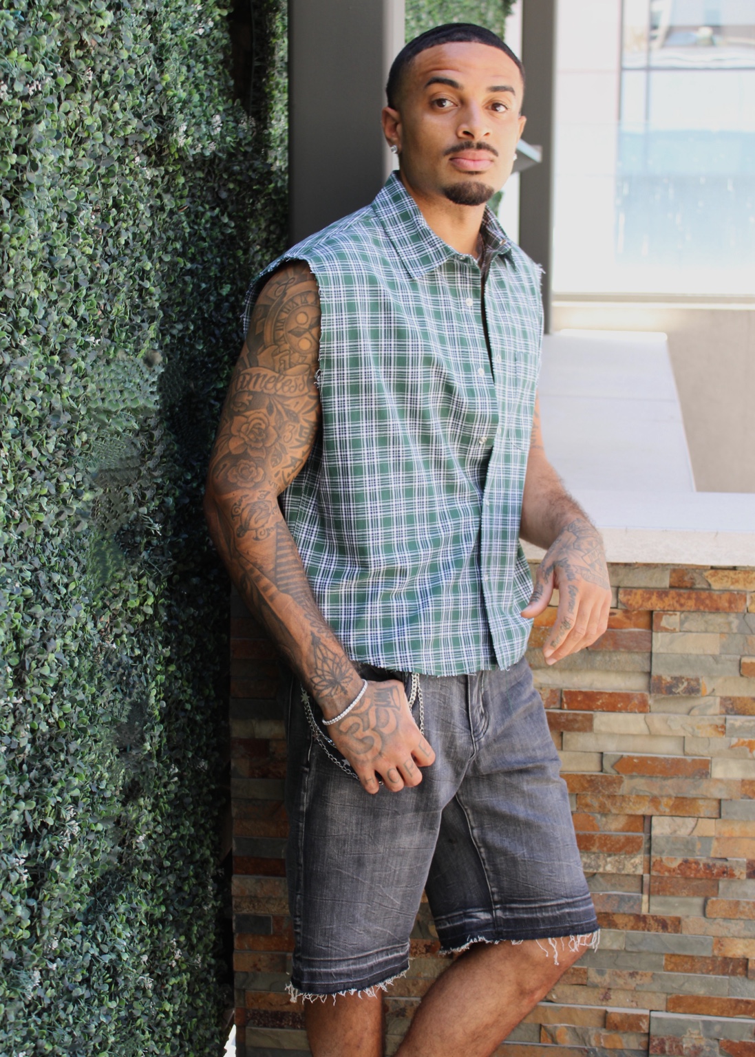 James Muhammad commercial fashion portrait standing in green plaid sleeveless shirt