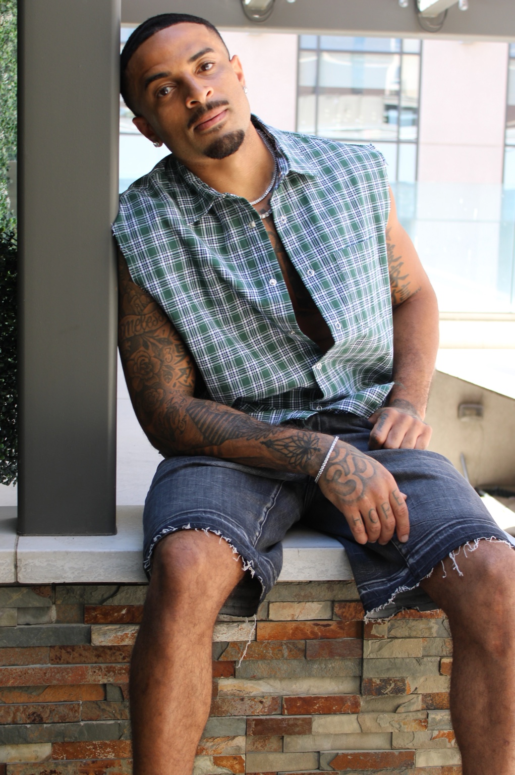 James Muhammad relaxed commercial lifestyle portrait in green plaid sleeveless shirt