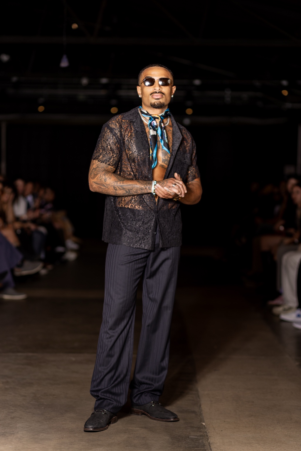 James Muhammad runway portrait in black lace shirt and sunglasses